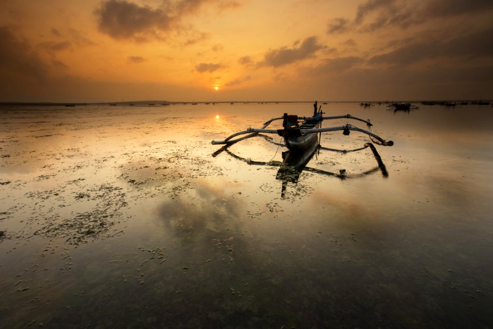 Brown Canoe Docked On Sea photo