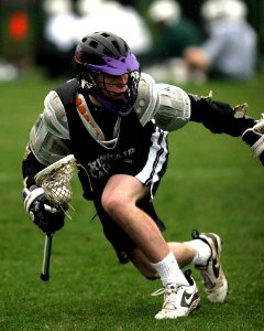Person In Black Sports Jersey Playing Lacrosse