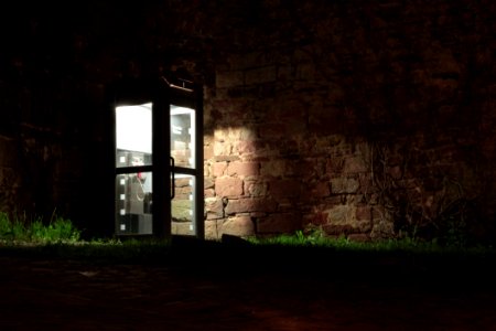 Telephone Booth Beside Brown Wall During Nighttime