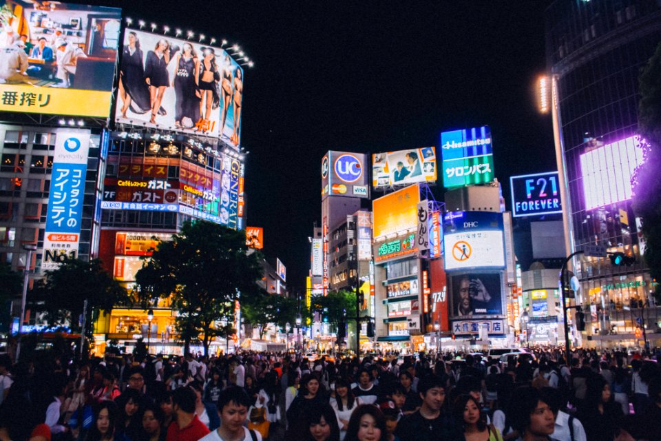 People Standing Near Buildings Under Night Sky photo