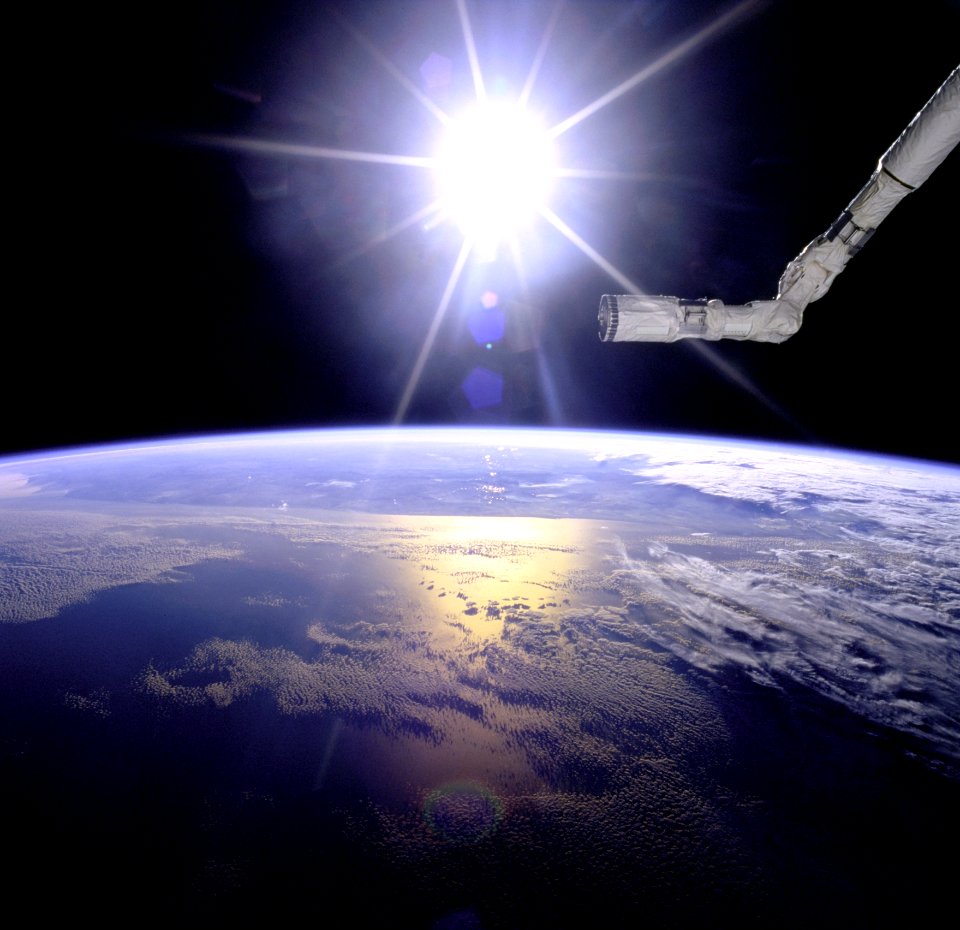 Robot Arm Over Earth With Sunburst