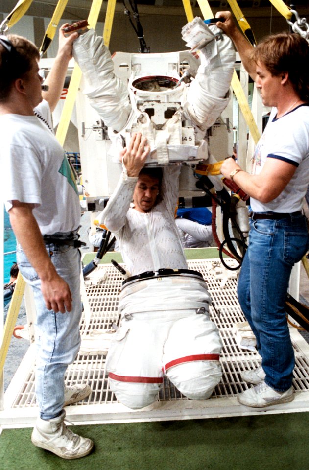 STS-38 Mission Specialist Robert C Springer Dons Extravehicular Mobility Unit (EMU) Upper Torso With Technicians
