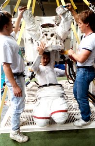 STS-38 Mission Specialist Robert C Springer Dons Extravehicular Mobility Unit (EMU) Upper Torso With Technicians