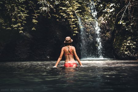 Rear View Of Young Woman Tourist With Straw Hat In The Deep Jungle With Waterfall Real Adventure Concept Bali Island