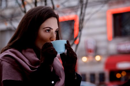 A Woman Drinking Coffee Outdoors photo