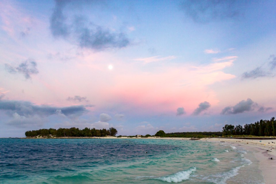 Full moon in the sunset as seen from the cargo pier
