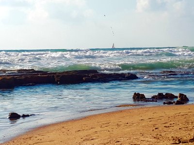 Rocks in the sea - by coincidence a fishing float seen over the sailboat photo