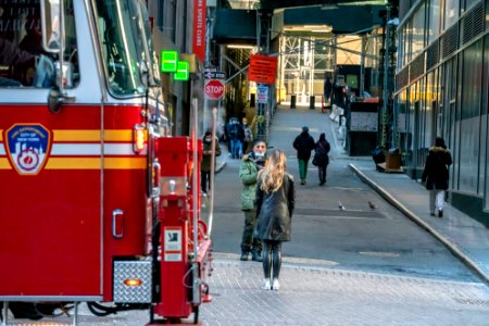 Woman posing for an iPhone and a firetruck crossing the frame