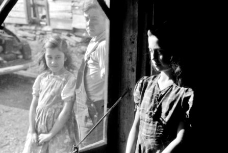 The Three of Us: Two of the Dumond children at the back door of their home in Lille, Maine. The family are French-Canadian potato farmers and Farm Security Administration clients, October 1940. photo