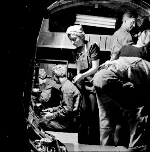 A team of workers completing assembly and fitting operations on the interior of a fuselage section of a B-17F, 1942. photo