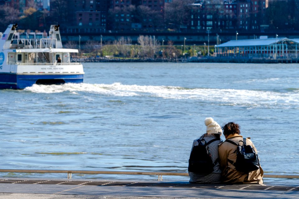 To women sitting together in East River Park in January
