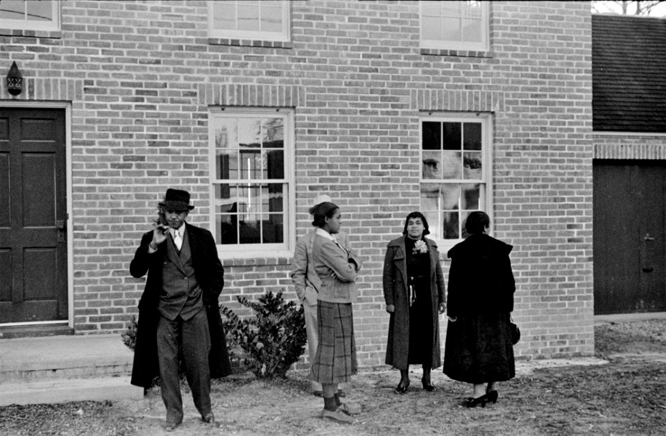 Neighbors congregate outside a new home in a New Deal housing development. Near Newport News, Virginia. October 1937.