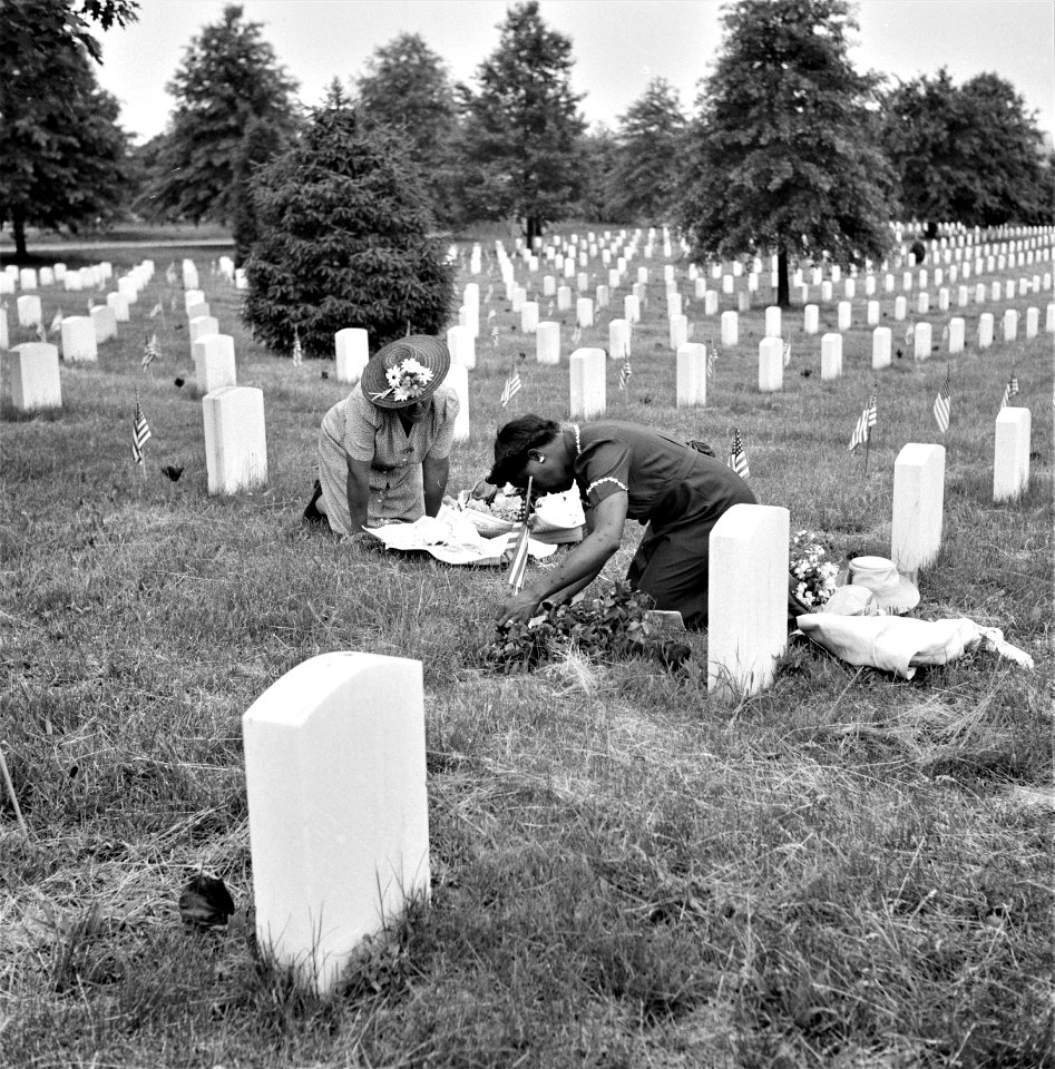 But Not Forgotten: Decorating a soldier's grave in one of the Black sections of Arlington National Cemetery on Memorial Day. Arlington, Virginia. May 1943.