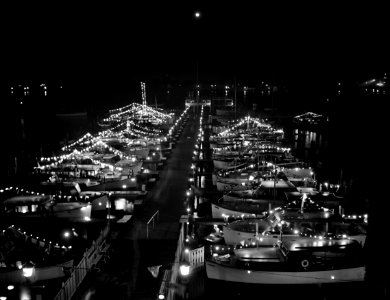 A Venetian night party at the Detroit yacht club, whose members represent the wealthier class of manufacturers and their friends. Cabin cruisers and sailboats decorated with lights 1940.