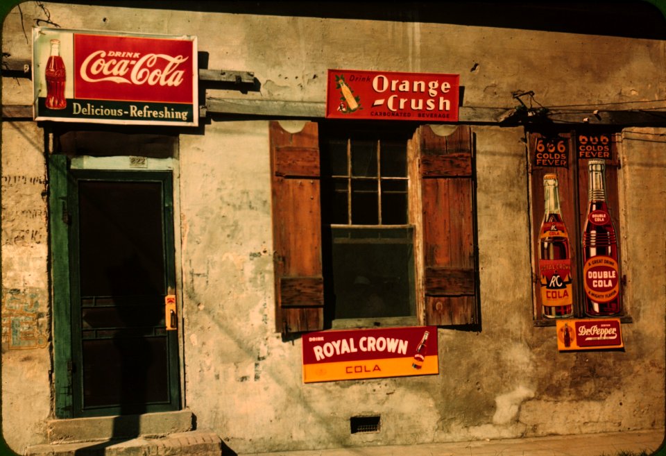 Storefront with advertising signs in Natchez, Mississippi. August 1940.
