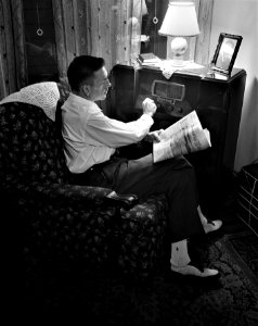 And Now, the News: Mr. Babcock, an American war worker, tuning in for war news on his radio. Rochester, New York, 1943.