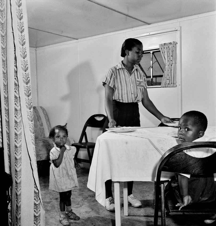 A Farm Security Administration housing relief camp for African-Americans. Interior of an expansible trailer, showing one wing used as a dining and living room, Arlington, Virginia. April 1942.