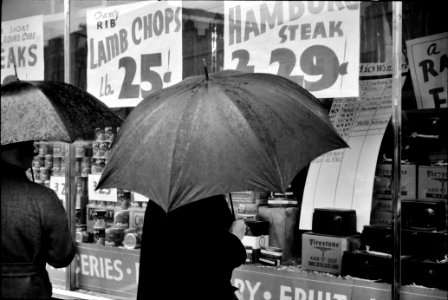 A Woman window shopping on a rainy day in Norwich, Connecticut. November 1940.