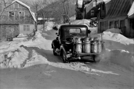 Milk Run: Farmer's Co-op truck full of milk cans driving into town, 1940.