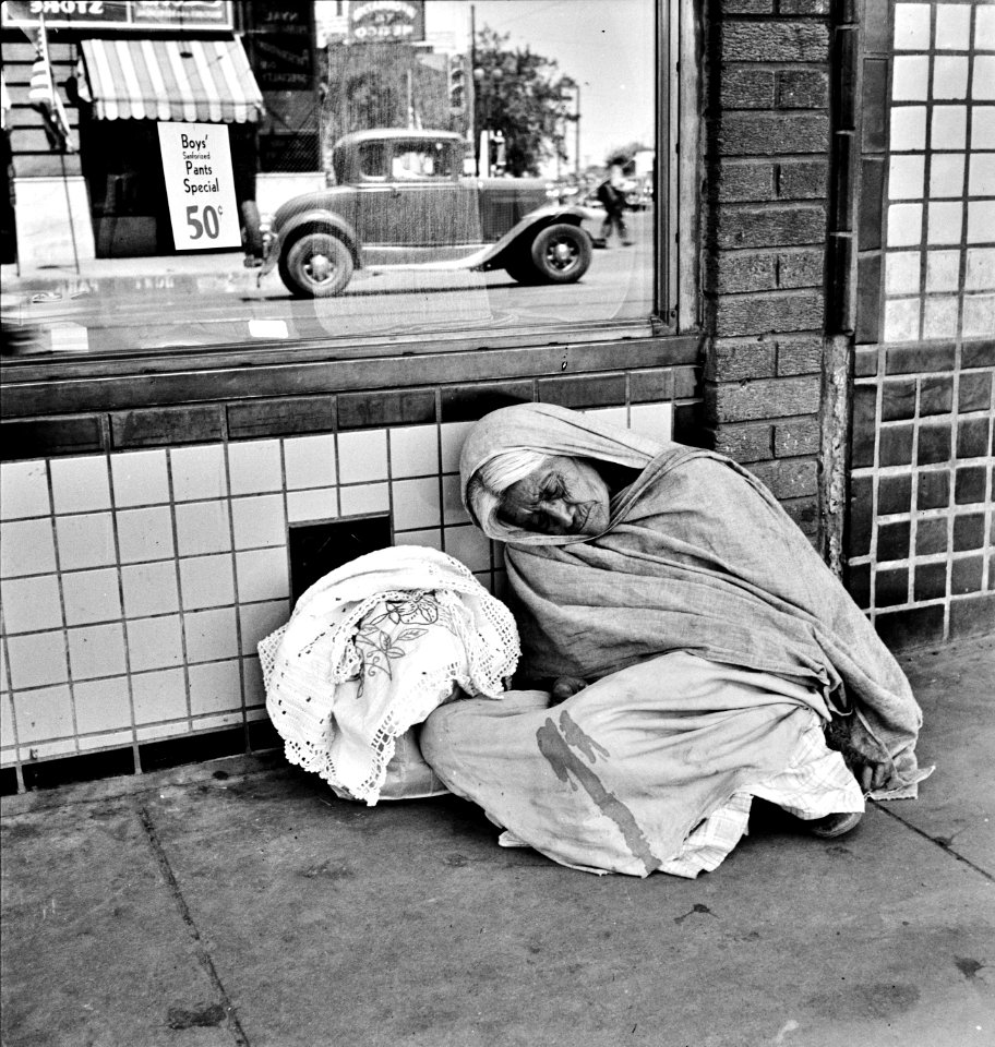 There and Back Again: An elderly woman awaits the international streetcar at a corner in El Paso, Texas to return across the bridge after a day of business, June 1938.