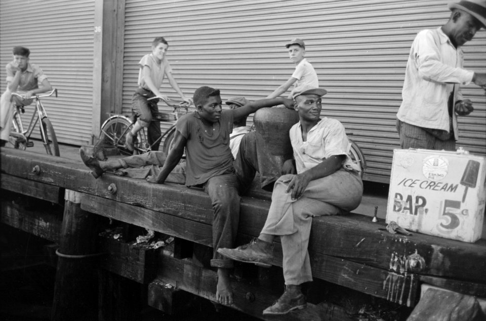 Big Easy: People sitting on dock, New Orleans, Louisiana, September 1938.