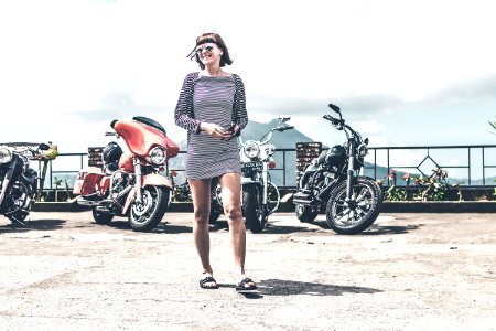 BALI, INDONESIA - AUGUST 12, 2018: Woman on the Harley Davidson motorcycles background, Batur volcano. photo