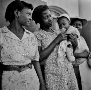 Ice Cream Social: A mother and child with an ice cream cone in front of the bank in San Augustine, Texas. April 1943. photo