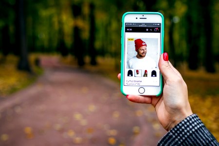 Woman hand with smartphone. Fall background. photo