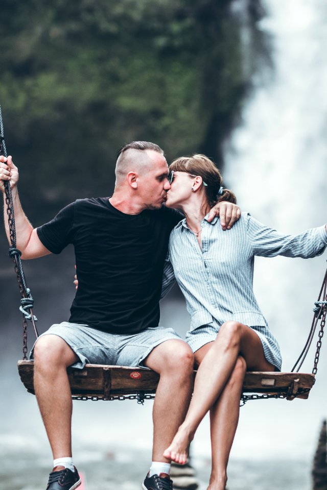 Young honeymoon couple swings in the jungle near the waterfall, Bali island, Indonesia. Ubud.