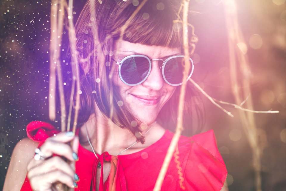 Close up shot of stylish young woman in sunglasses smiling. Beautiful female model with copy space. Bali island.