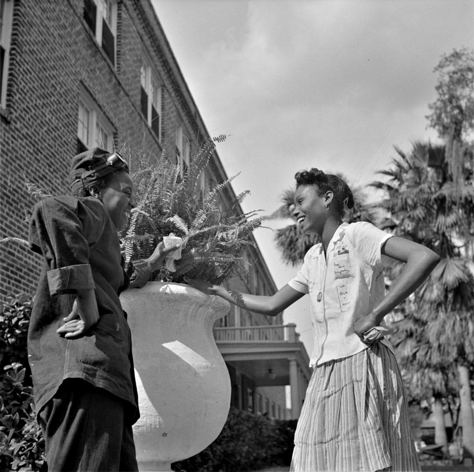 Through the Grapevine: Two NYA (National Youth Administration) students at Bethune-Cookman College chatting between classes on the campus. Daytona Beach, Florida. January 1943.
