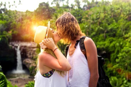 Young couple kissing on a waterfall background photo