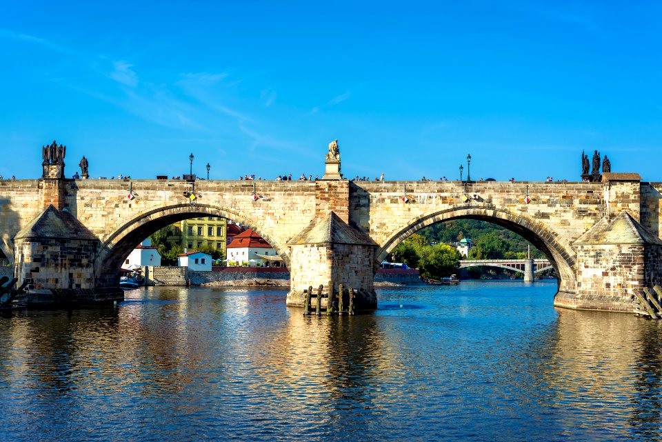 Charles Bridge over Vltava River against blue sky. Prague, Czech Republic photo