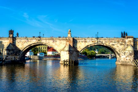 Charles Bridge over Vltava River against blue sky. Prague, Czech Republic