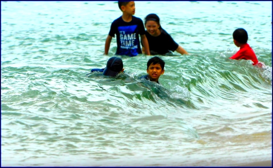 children swimming during high tide