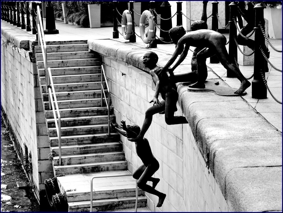 statues of naked children jumping into river
