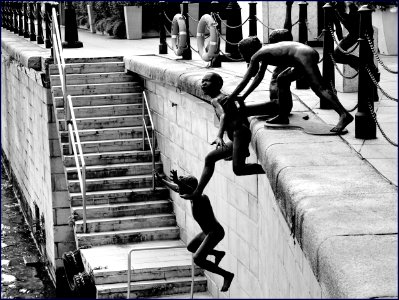 statues of naked children jumping into river photo