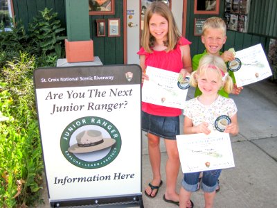 Three Junior Ranger Program graduates with their certificates at the Namekagon River Visitor Center photo