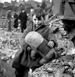 1940 - Un niño sostiene un animalito de peluche en los escombros luego de un bombardeo en Londres