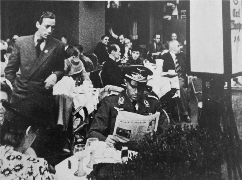 1939 - Un brigadier general de la Luftwaffe lee las noticias sobre la guerra en un café de Berlín