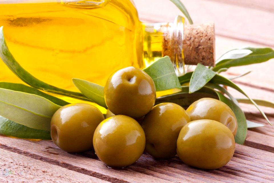 aceitunas verdes con aceite y hojas