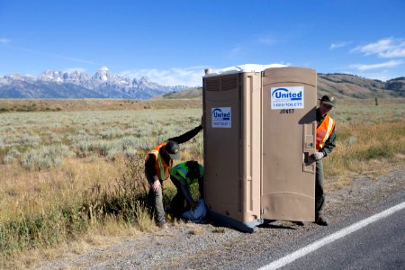 Employees placing portable toilets on Gros Ventre Road