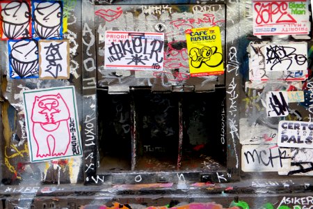sticker-and-graffiti-covered wall with openings