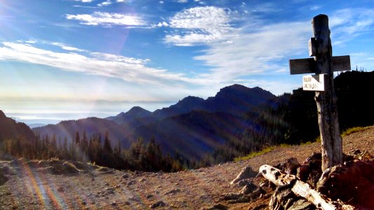 The peaks of the North Cascades are visible across Puget Sound as sunrise lights up the PNT at Marmot Pass in Olympic National Forest