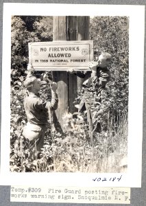 Fire guard posting fireworks sign, Snoqualmie N.F