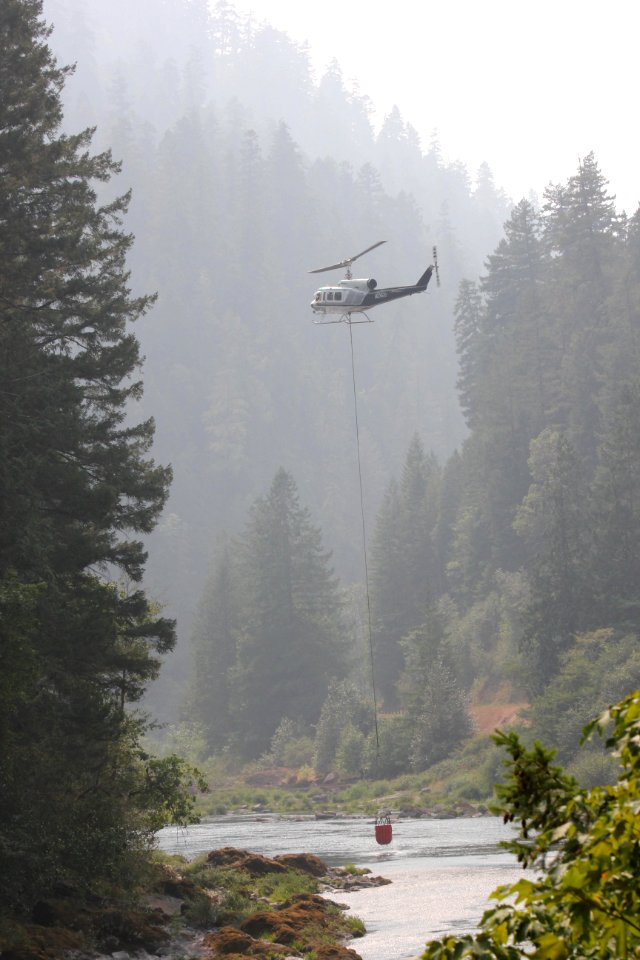 A helicopter dips a bucket of water out of the North Umpqua River on Wednesday, Aug. 23, 2017, Umpqua North Complex. Tim Mowry, Alaska Interagency Incident Management Team