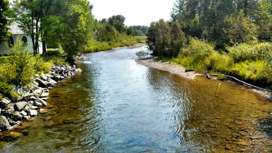 The Tobacco River flows past a historic church building in downtown Eureka, Montana