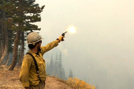 Firefighter shoots flare to ignite fuel, Staley Fire, 2017 photo