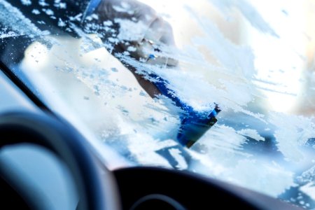 Removing frost from car windshield photo