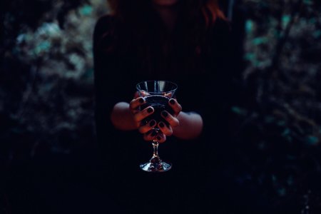 A witch holding a glass of wine